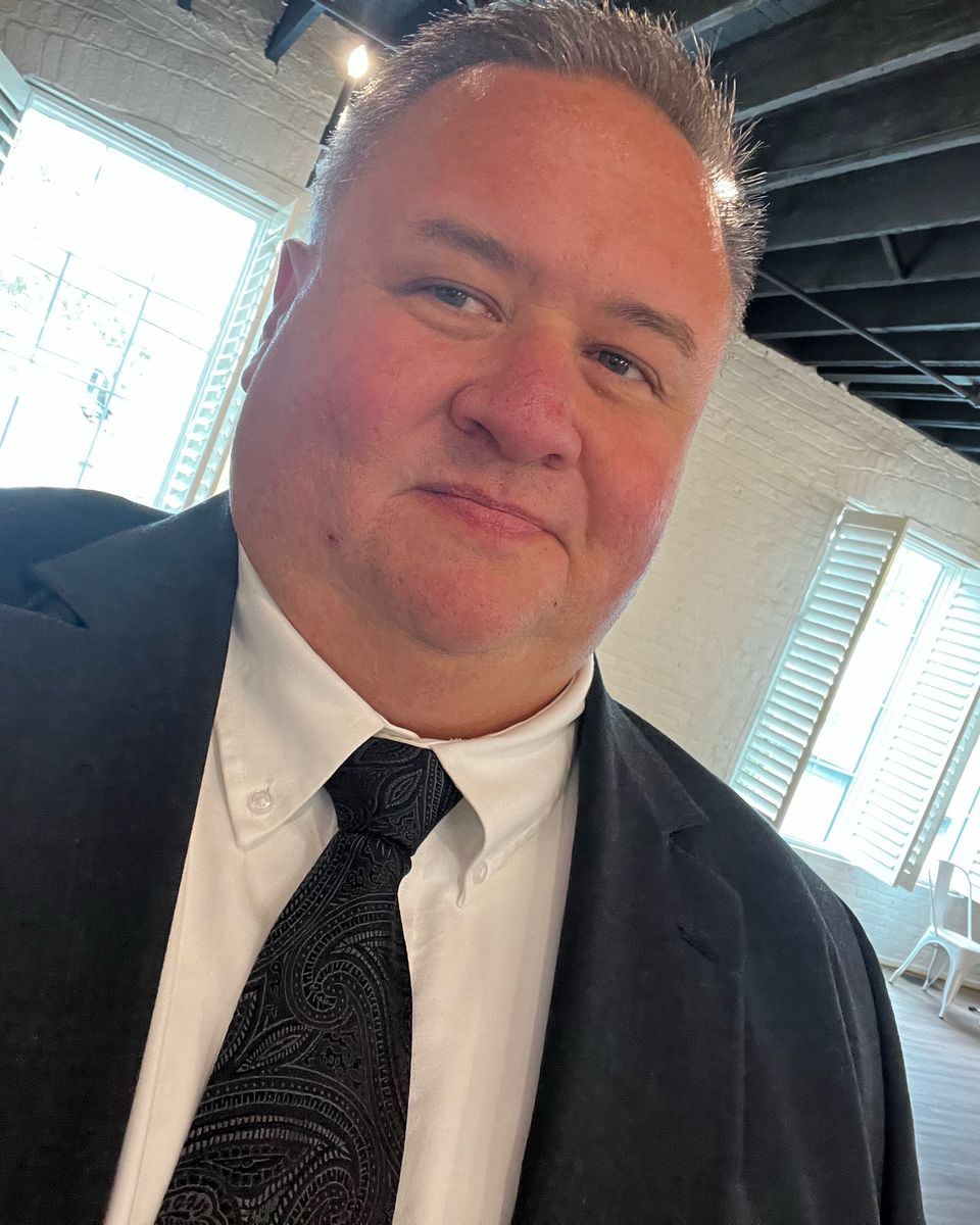 Brian Cardinal in a dark suit and tie